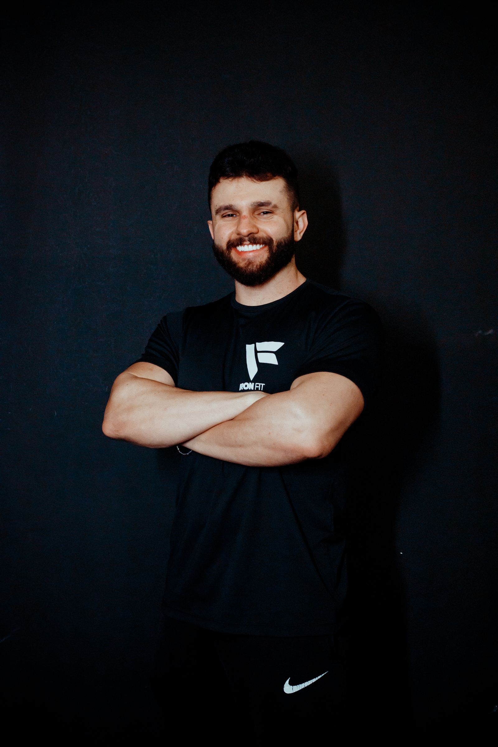 foto do personal trainer Saldanha de braços cruzados em fundo escuro